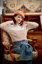 a lady wears a striped knitwear with jeans